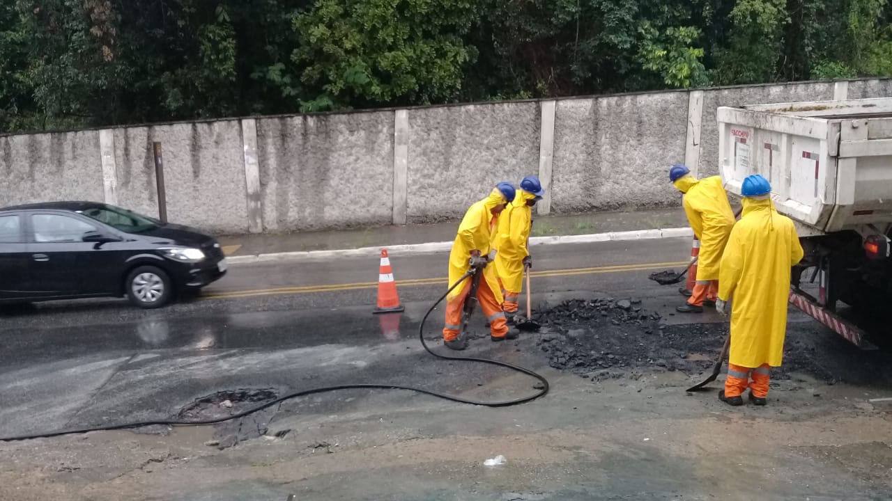 Foto 2: Quatro funcionários da Subprefeitura Ipiranga realizando a operação tapa-buraco enquanto chove